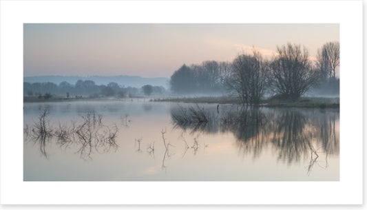 Sunrise glow over misty lake