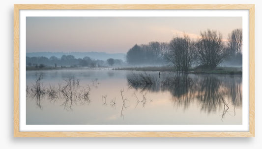 Sunrise glow over misty lake