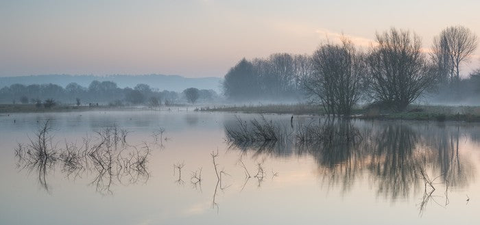 Sunrise glow over misty lake