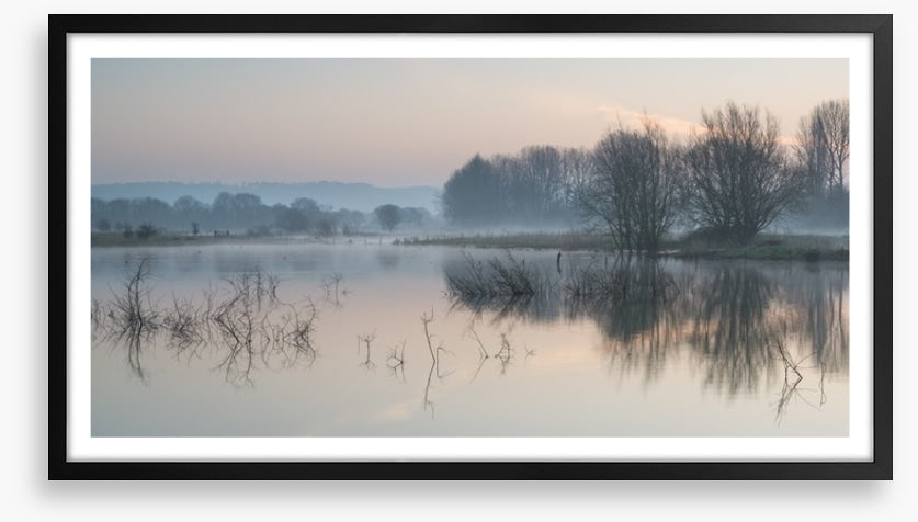 Sunrise glow over misty lake