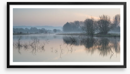 Sunrise glow over misty lake