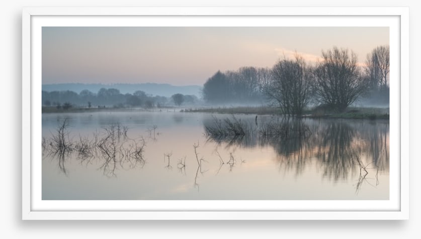 Sunrise glow over misty lake