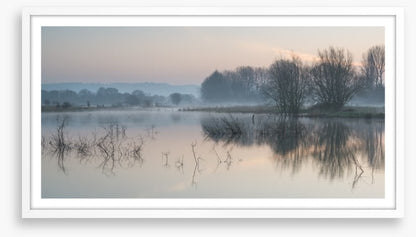 Sunrise glow over misty lake