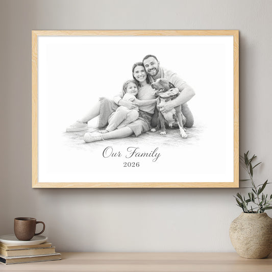 Framed family photo with 'Our Family 2026' text on a wall above a wooden shelf.