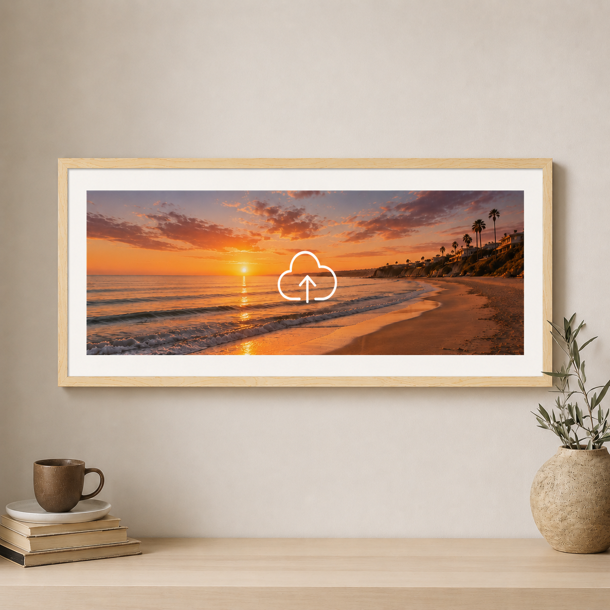 Framed beach sunset print on a wall with a cup and books below