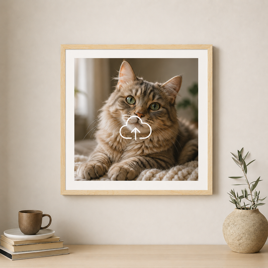 Framed picture of a cat on a wall with a cup and plant below